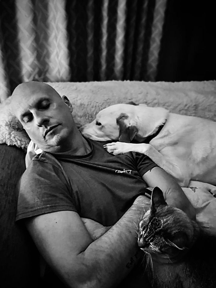 christian with dilly the dog and jasper the cat all asleep on the sofa